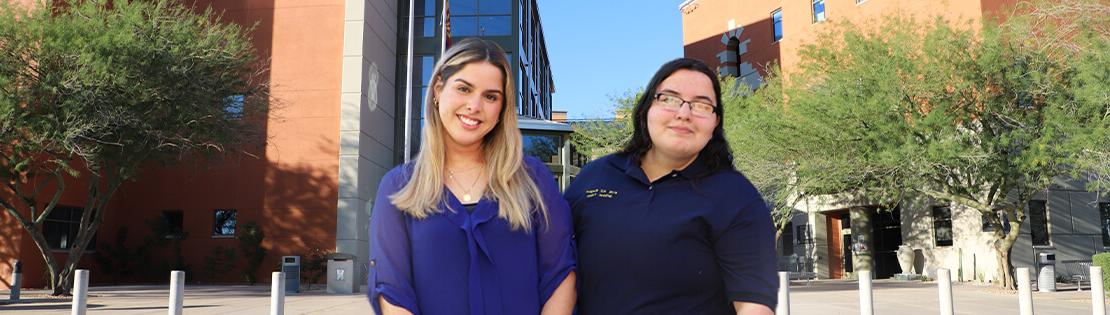 Pimaâ€™s Andrea Salazar Calderon and Halianna Piller stand smiling in front of Northwest Campus